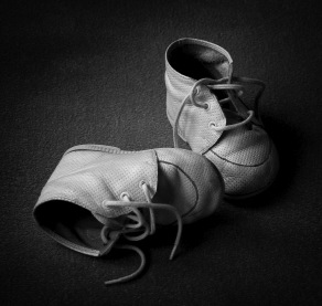 Pair of old tiny baby shoes. Black and white with copyspace.